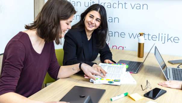Studenten wijzen iets aan in de wettenbundel