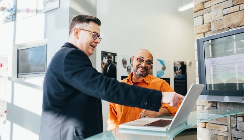 twee mannen wijzen op laptop