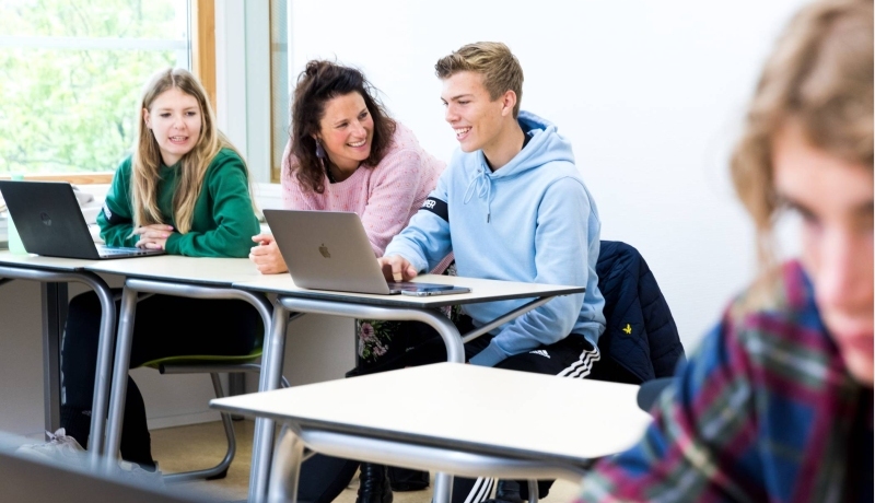 Pabo-ALO studenten sparren met hun docent in Pabo lokaal, achter de laptop. 