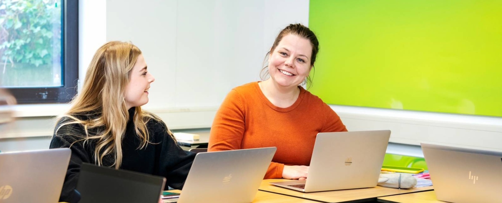 2 Cursisten in gesprek achter een laptop