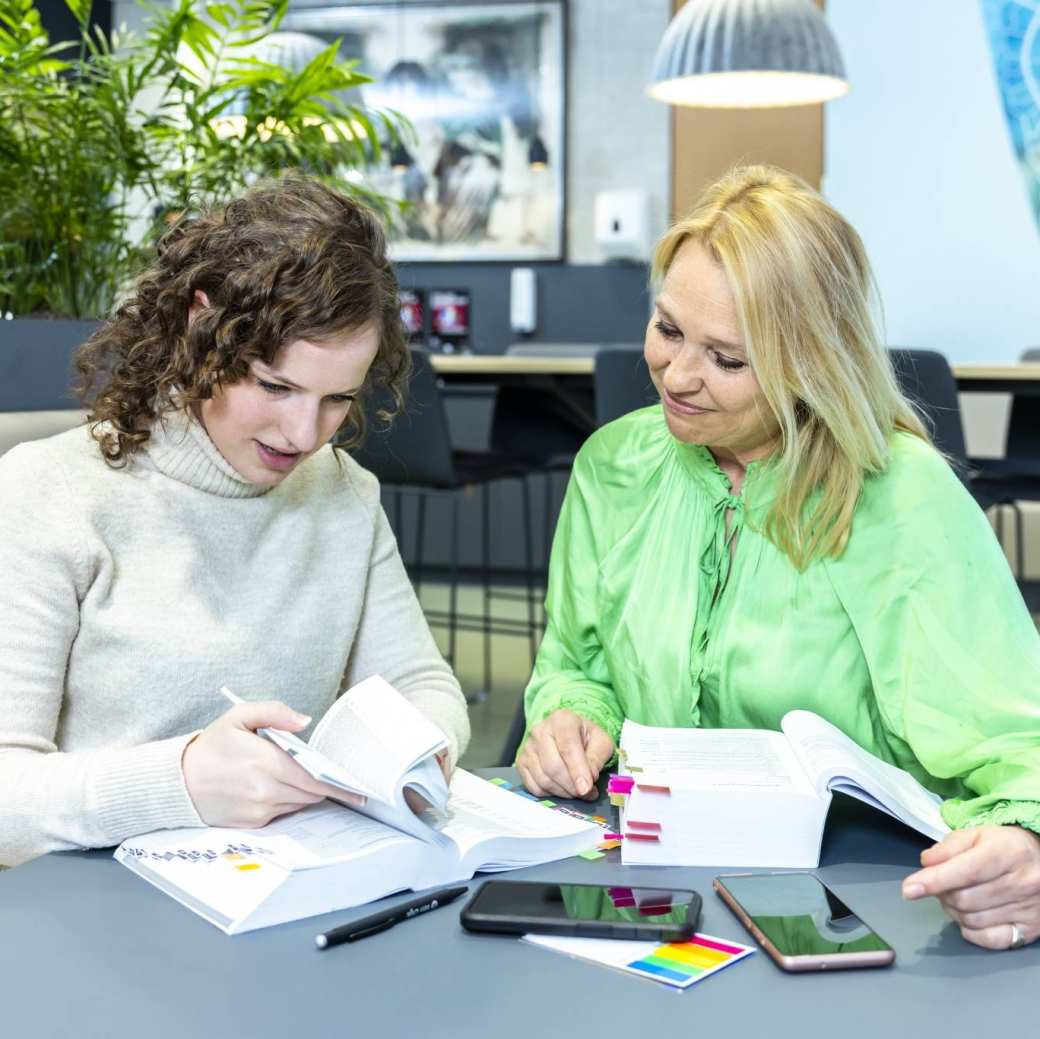 studenten accountancy deeltijd in overleg met lesboek in gemeenschappelijke ruimte HAN Arnhem, finance, financieel, AFEM