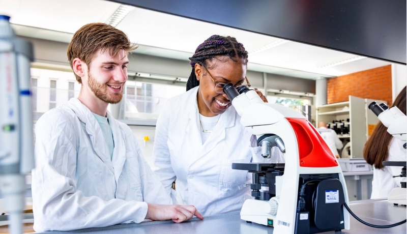 studenten aan het werk met een microscoop