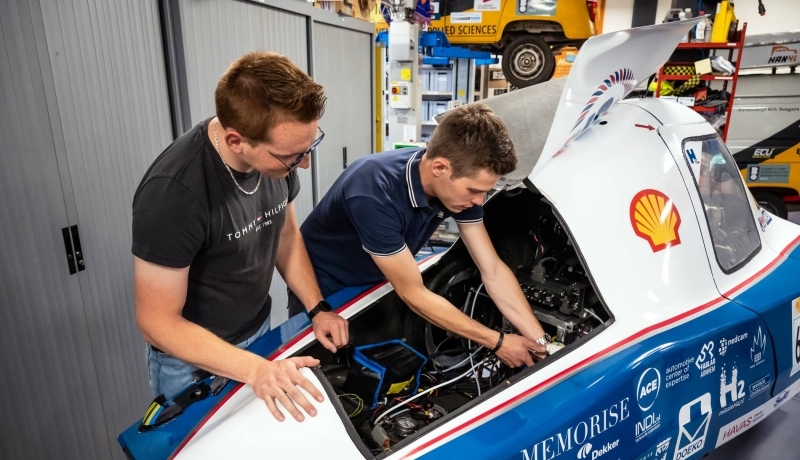 Automotive student bij voertuig.