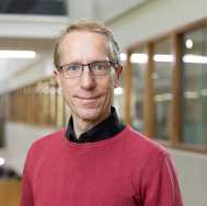 Brildragend, zwarte blouse, rode trui