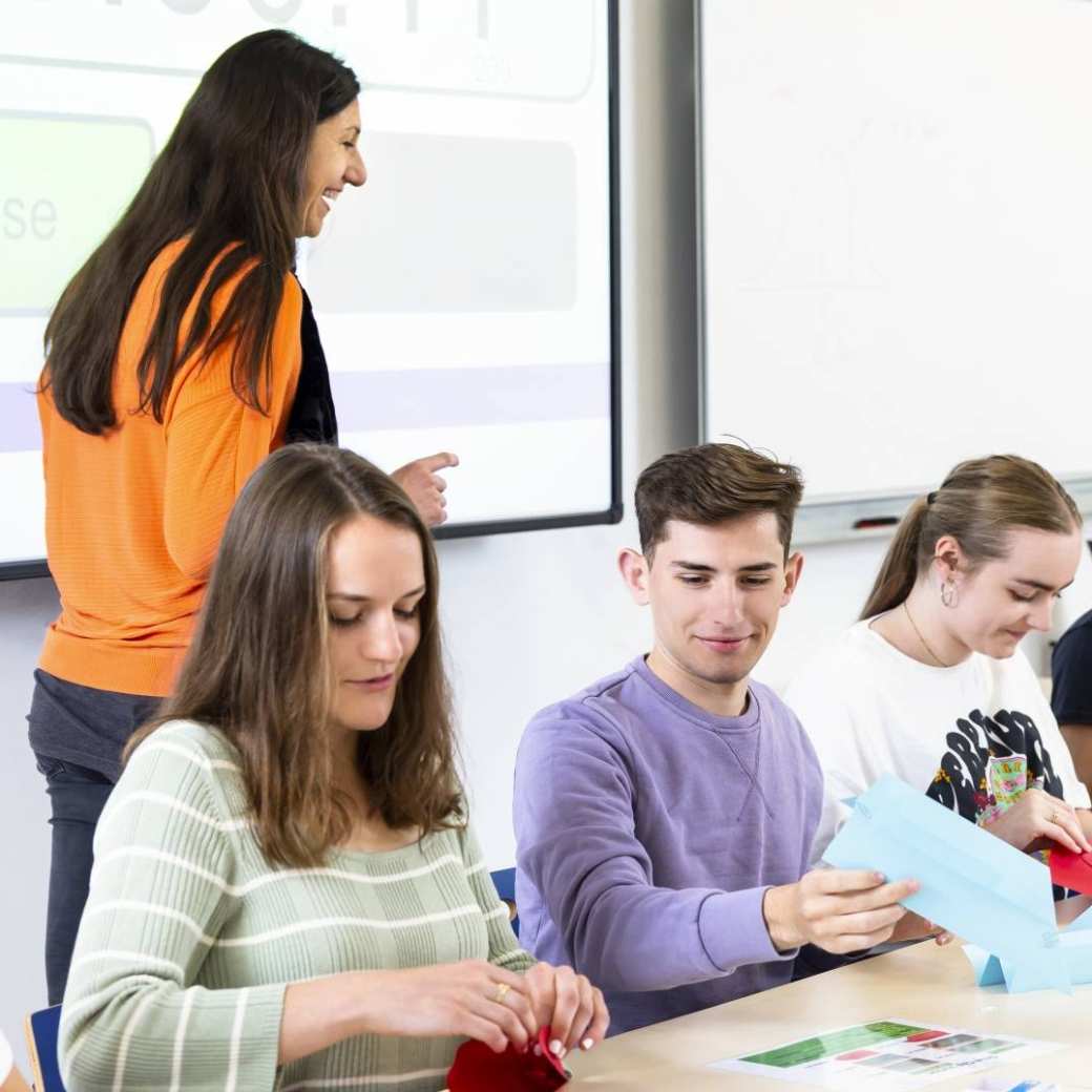 5 studenten die een les krijgen van 2 docenten