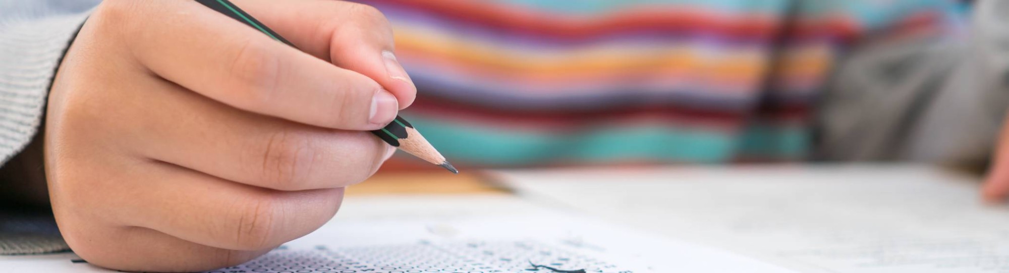iemand met pen in de hand die examen maakt