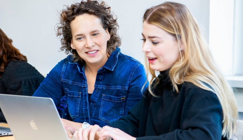 Docent en student met laptop bekijken lesstof