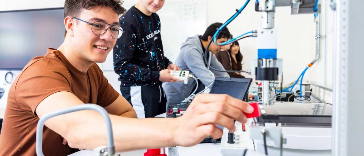Twee elektrotechniekstudenten werken samen aan een PLC.