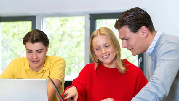 Studenten Facility Management in overleg met de laptop erbij