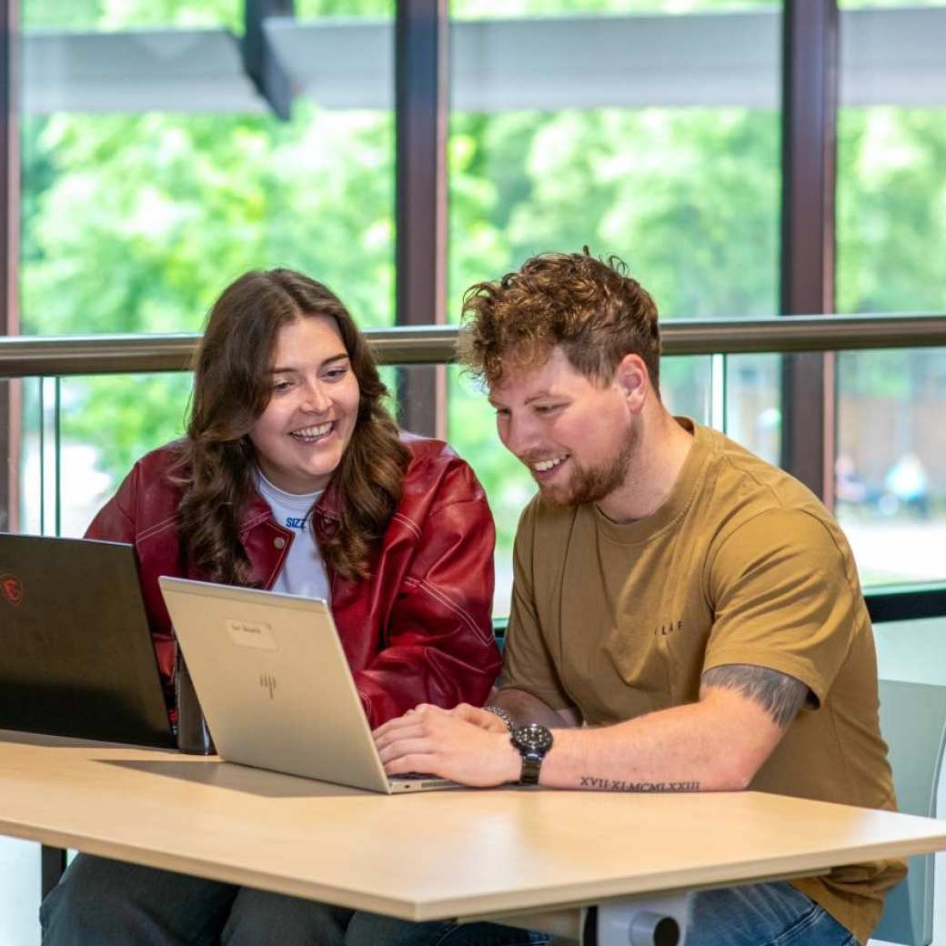 student ergotherapie zit achter laptop en is in gesprek