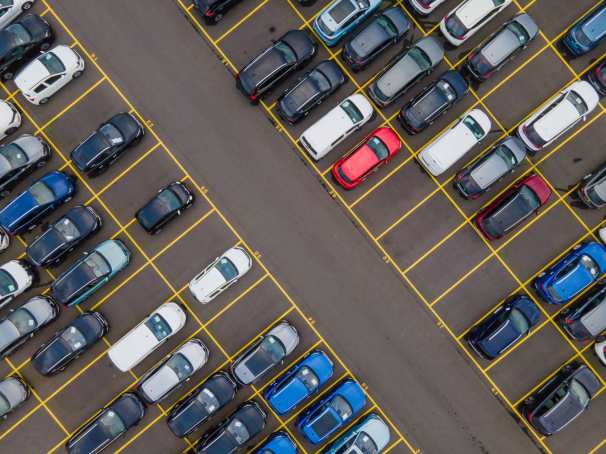 Bovenaanzicht van grote partij auto's die op een parkeerplaats klaarstaan om ete verschepen.