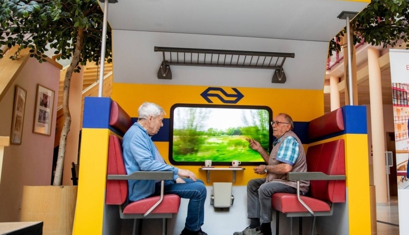 2 heren in een nagemaakte treincoupé
