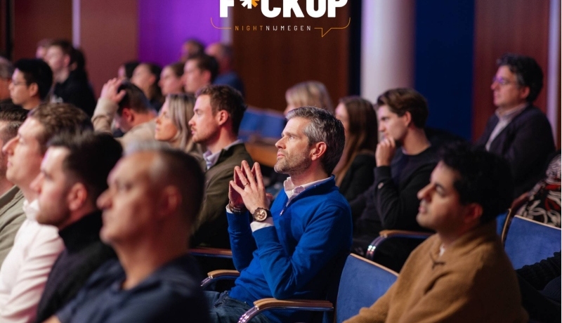 Een groep mensen luistert aandachtig tijdens een FuckUp Night