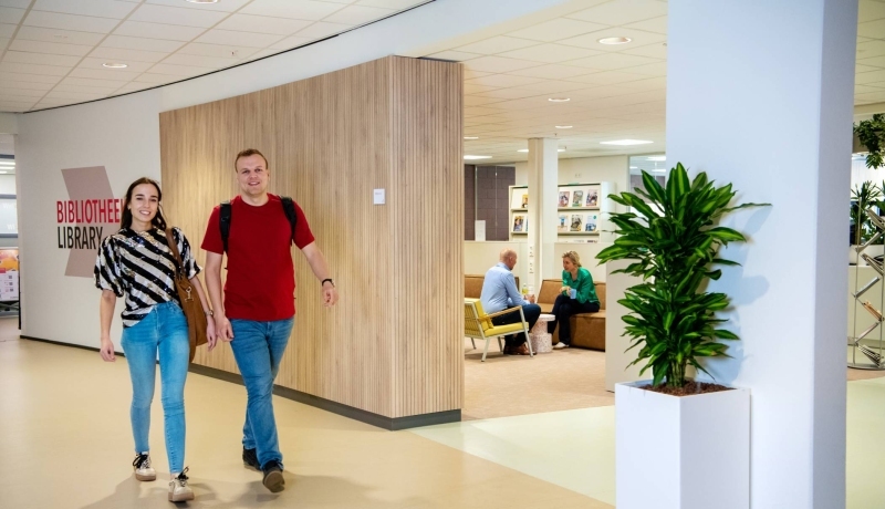 twee studenten van hbo logistiek deeltijd lopen door de gang op de HAN