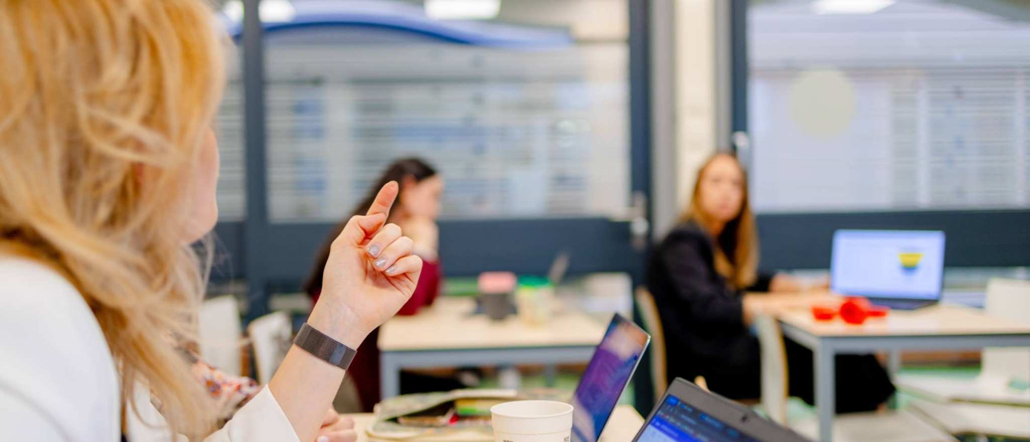 Studenten van de bachelor Commerciële Economie deeltijd, duaal in gesprek tijdens college.
