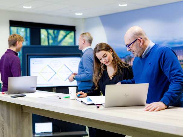 Studenten van de master Business Sales in overleg, samenwerken op laptop.