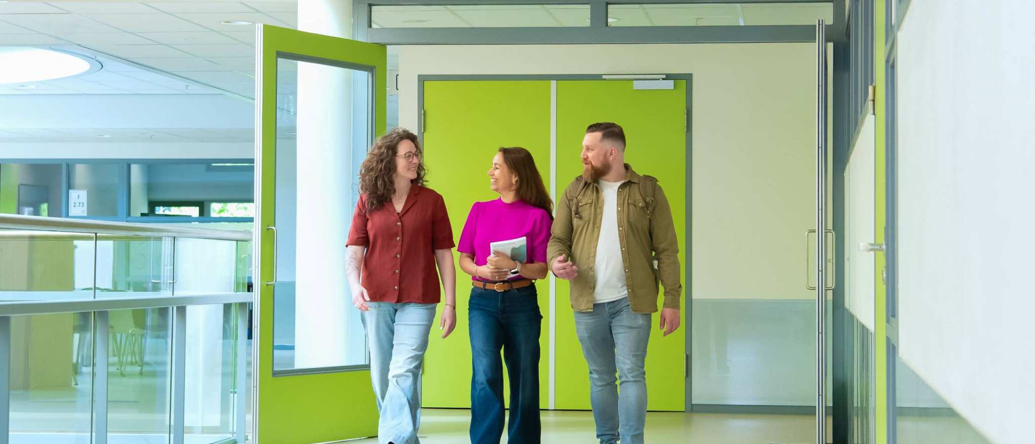 Studenten en docenten van de opleiding Learning & Development in Organisations deeltijd in gesprek terwijl ze door de gang lopen op de Laan van Scheut 10.