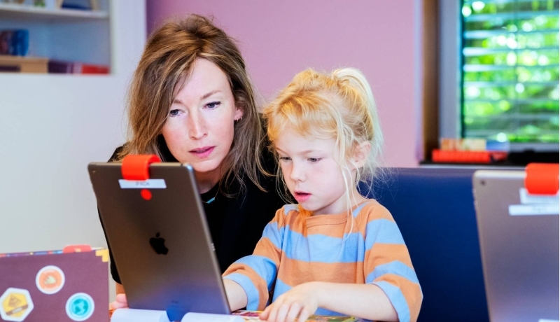 De vrouw en het kind kijken samen naar de iPad