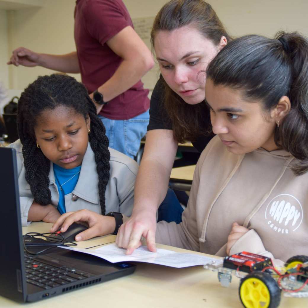 Leerlingen Iglesias en Dishita achter de laptop in de klas met Marlon