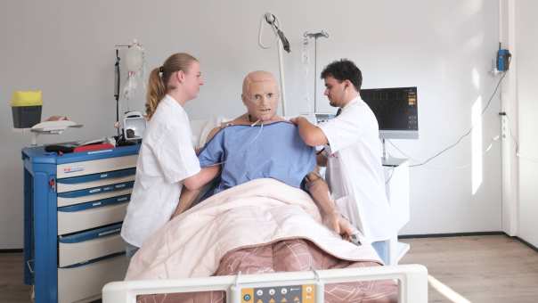 Medische Hulpverlening studentes maken een hartfilmpje van een pop in een praktijklokaal
