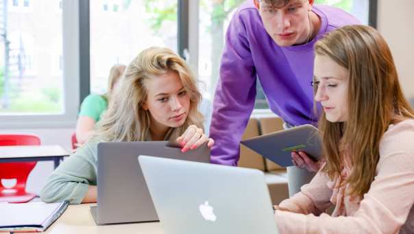 Studenten werken samen achter een laptop