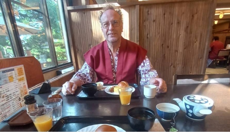 Dort Spierings met rode kimono aan tafel in Japan.