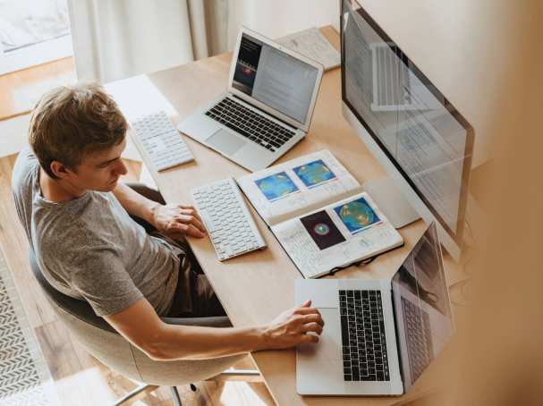 man met computer en laptops