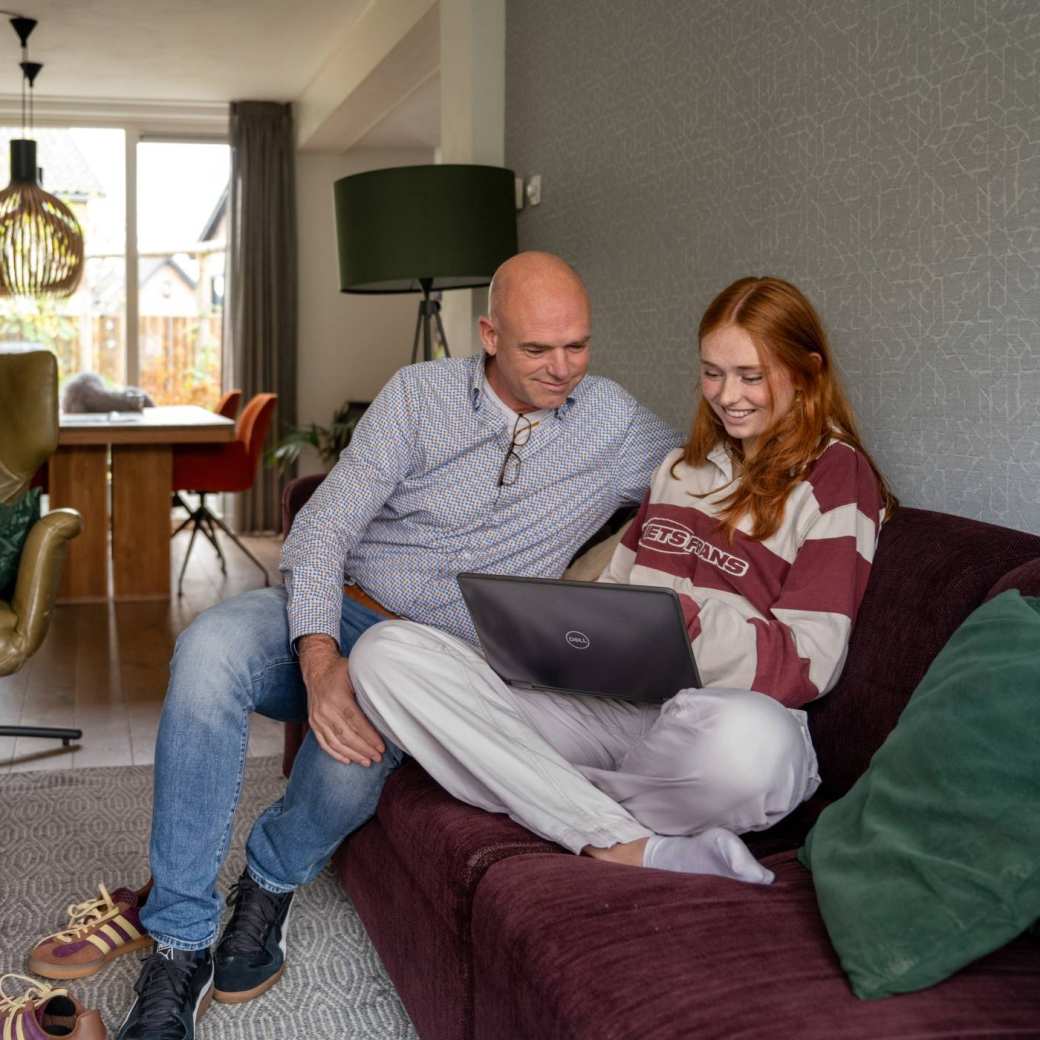 vader en dochter op laptop op de bank aanmelden han