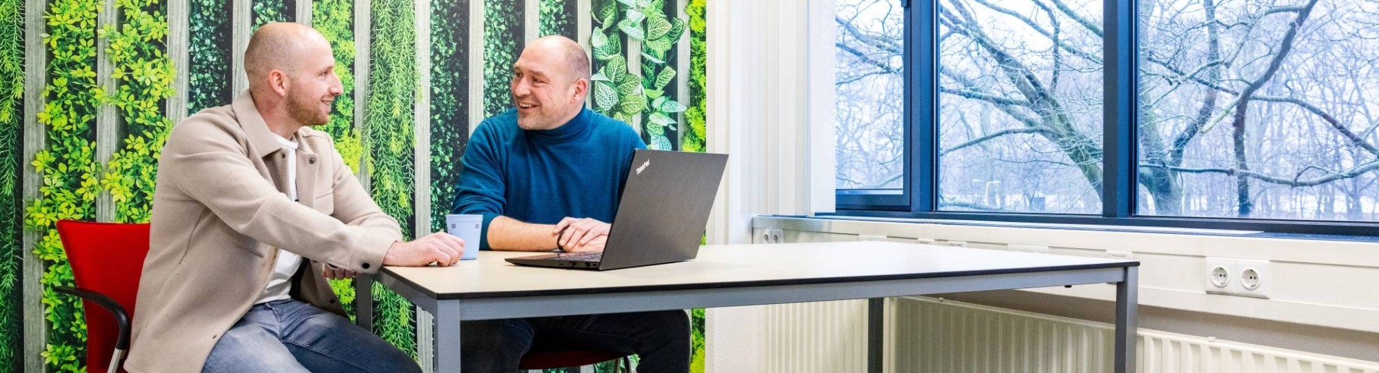 Een studieadviseur en docent heeft een gesprek met een student Bedrijfskunde deeltijd