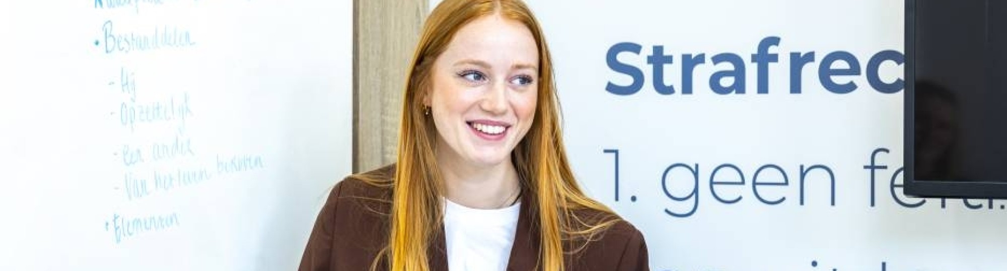 Student wijst iets aan het op het bord