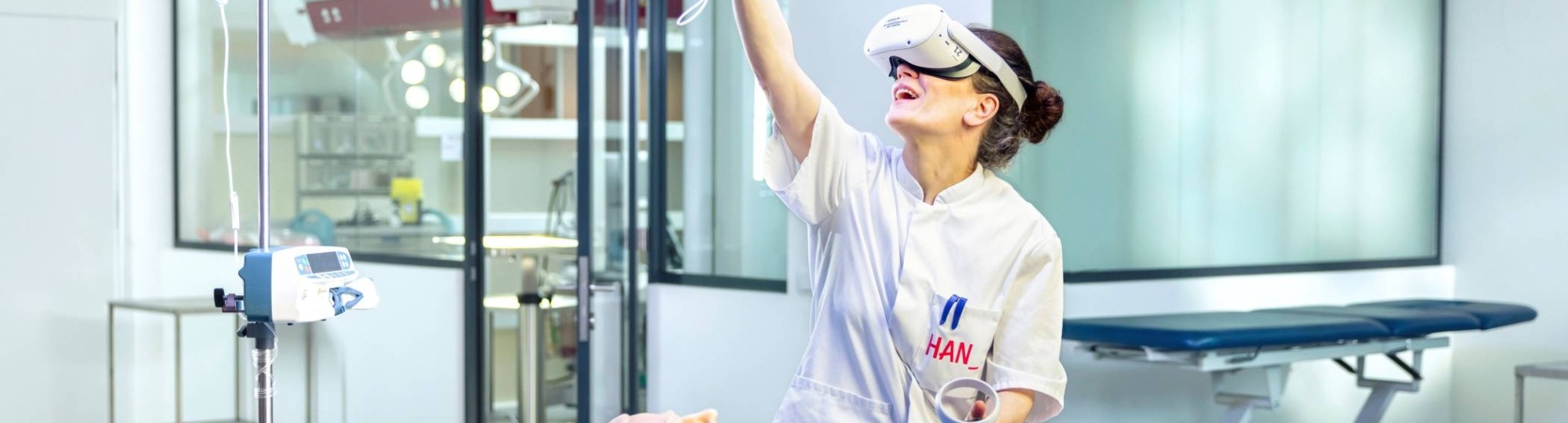 Verpleegkundige oefent met VR bril aan een ziekenhuisbed met dummy.