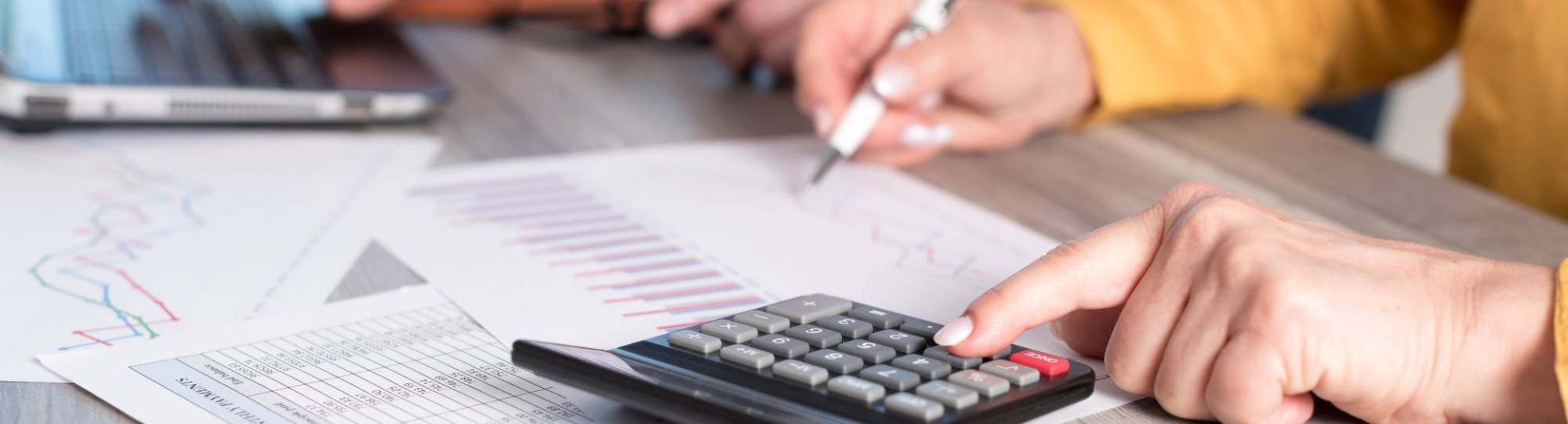 De armen van 2 mensen met een rekenmachine