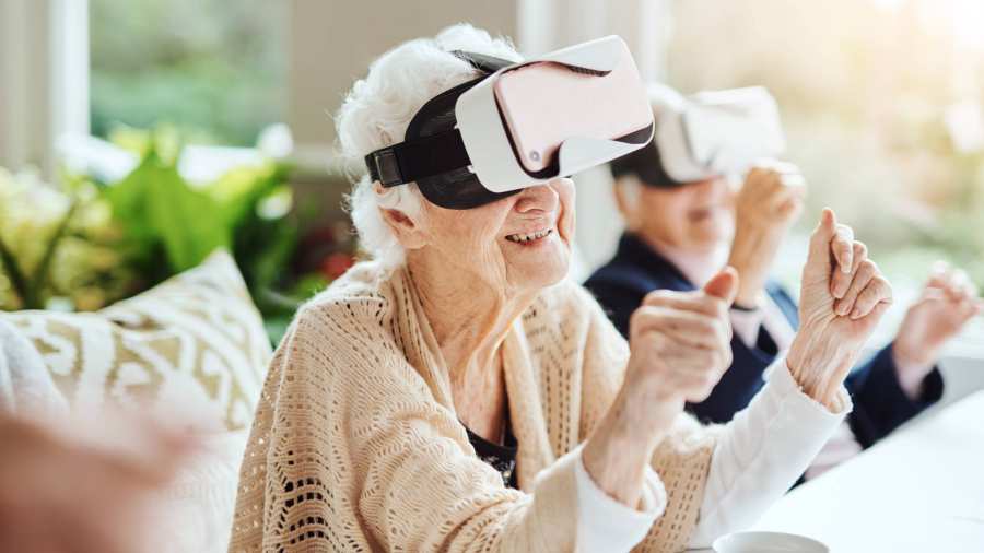oudere vrouw met vr bril zit aan tafel