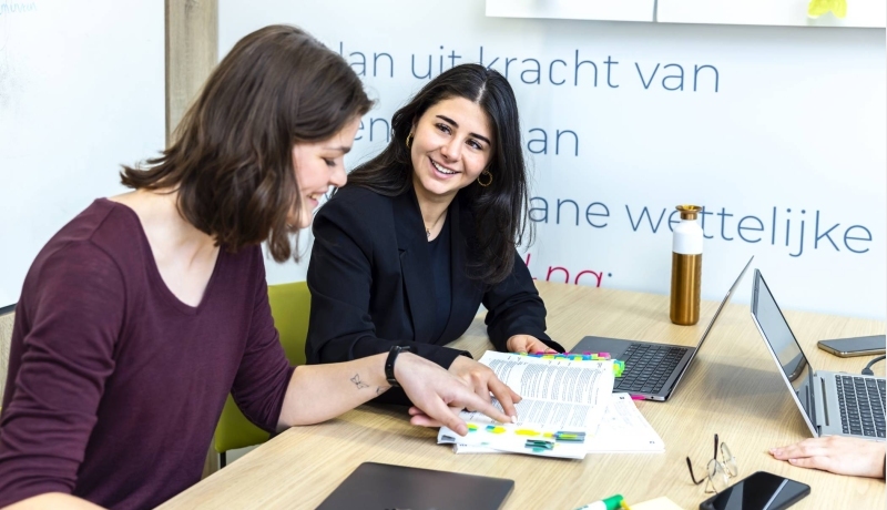 Studenten wijzen iets aan in de wettenbundel