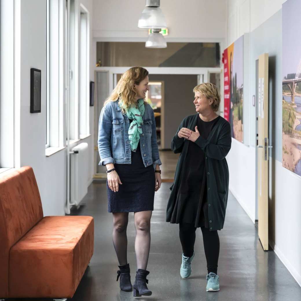 Twee docenten lopen door de gang Groenewoudseweg