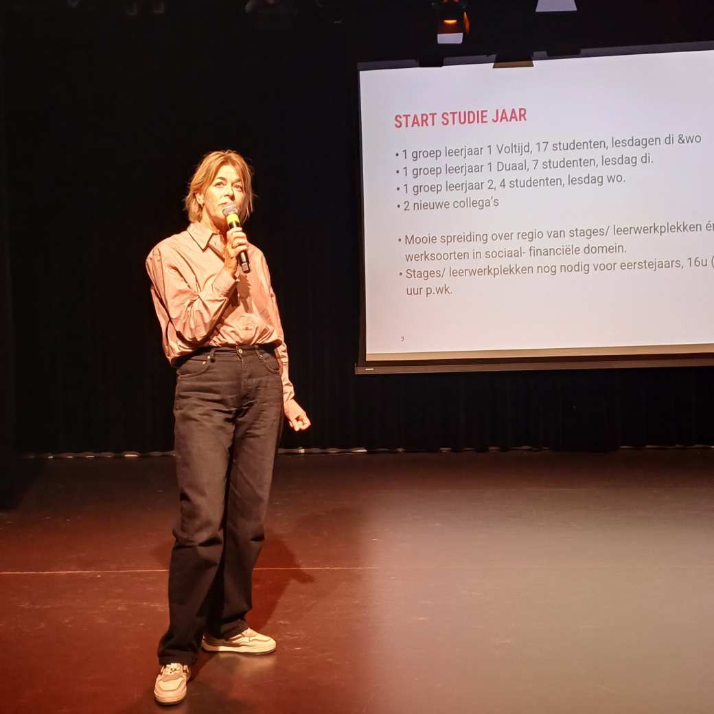 Teamcoordinator Ellen Schuurman staat voor een powerpoint waarop te lezen staat welke varianten er nu zijn van de opleiding Sociaal Financiële Dienstverlening