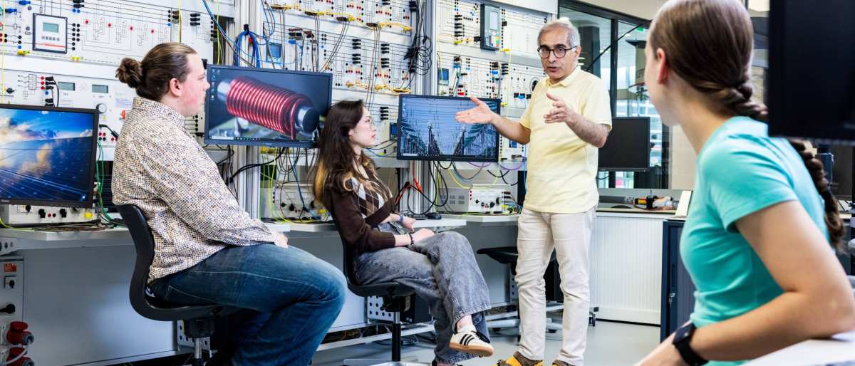 Studenten en docent elektrotechniek tijdens een les in het hoogspanningslab.