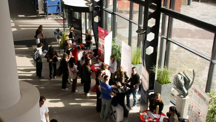 Netwerkmarkt 9 maart 2026, foto van boven genomen. Je ziet meerdere kraampjes met daarachter werkgevers en studenten die op zoek zijn naar een stage.