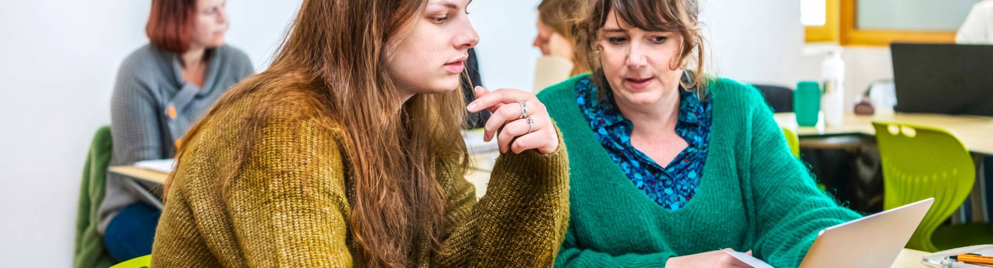 Twee studenten Leraar Engels werken samen op één laptop.
