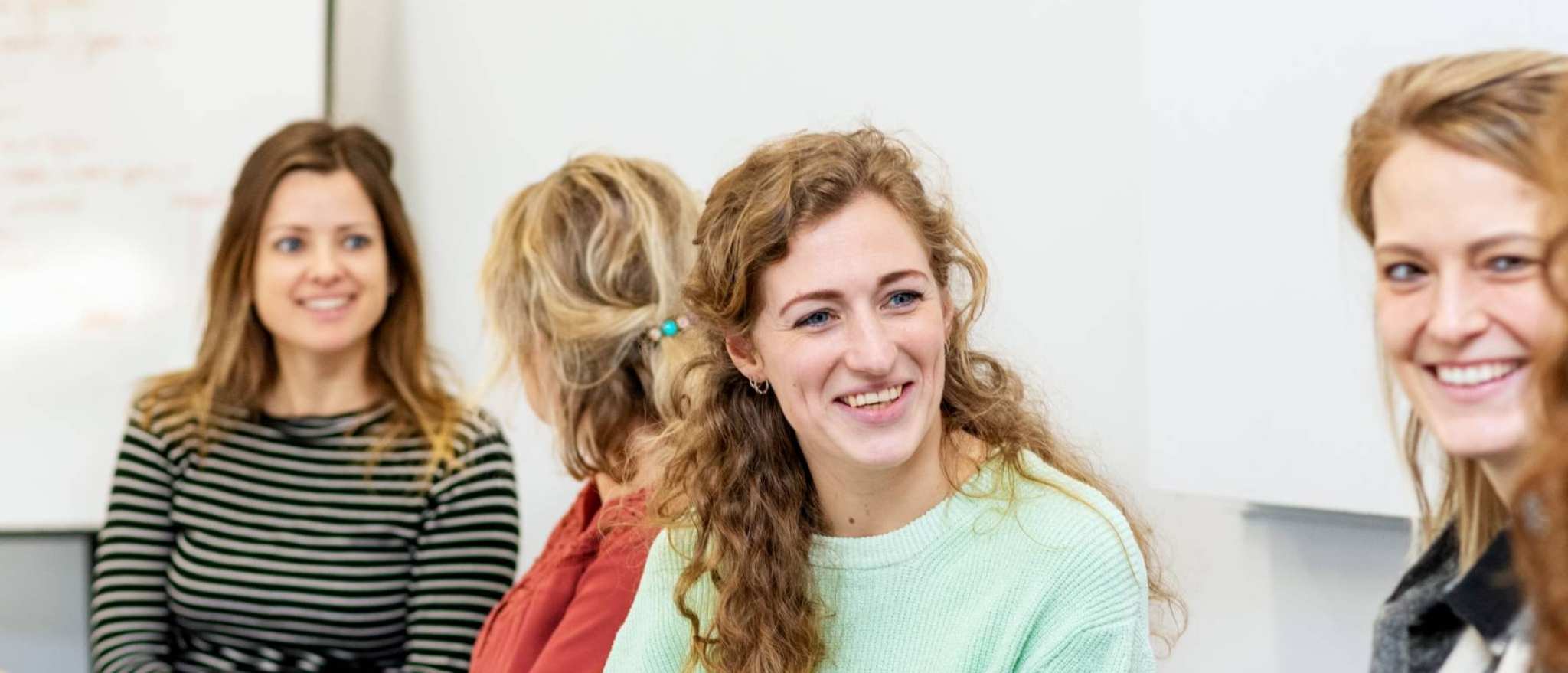 ALLEEN VOOR DE MANP | Lachende masterstudenten overleggen samen tijdens een klassikale les onderzoek op de HAN in Nijmegen.
