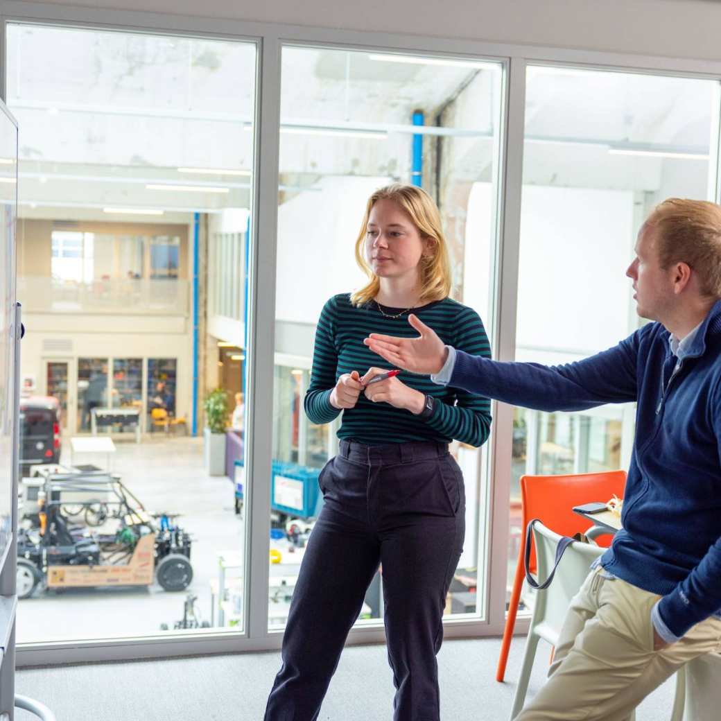 Twee studenten die samenwerken aan een flipover