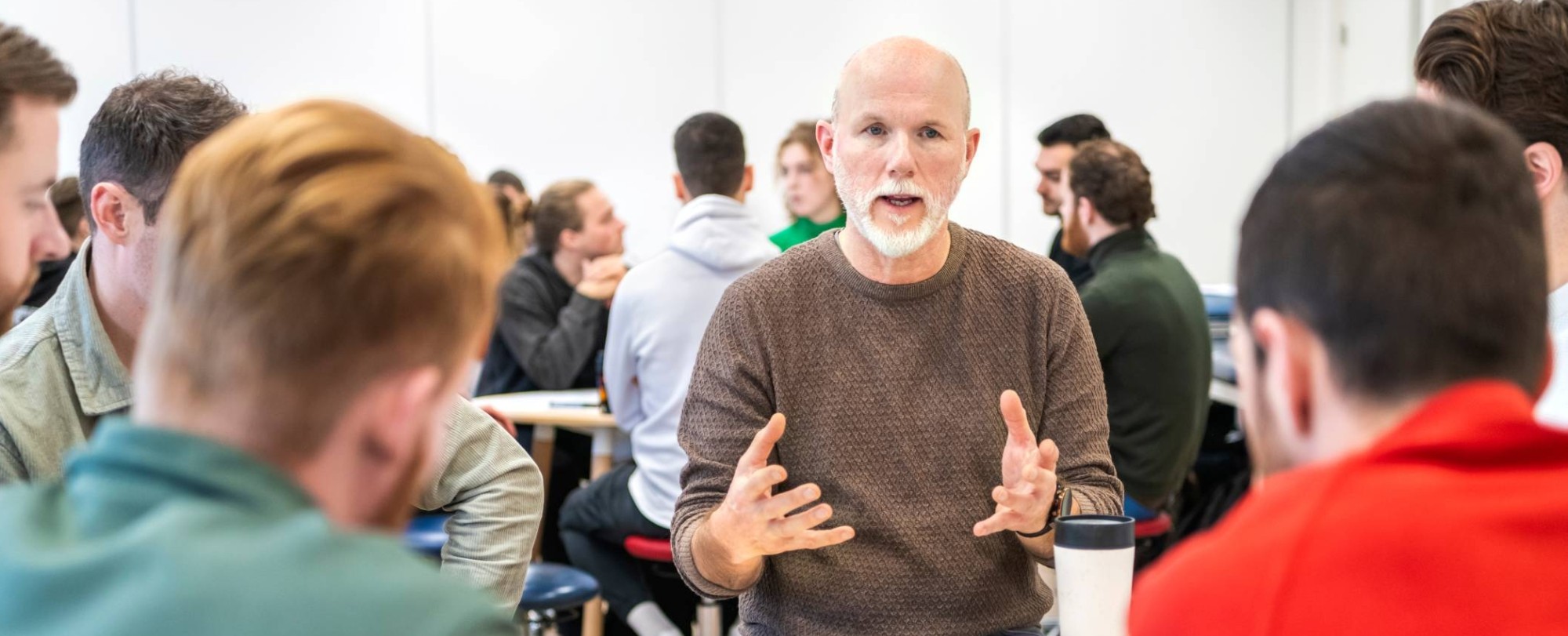Docent en studenten in gesprek aan tafel - klinisch redeneren