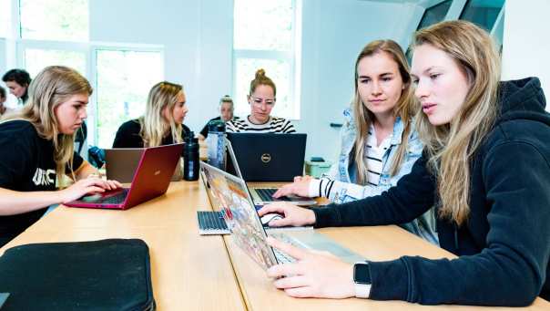 Studenten werken samen achter een laptop