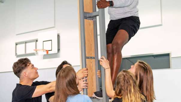Student Vaktherapie klimt in paal met ondersteuning van medestudenten
