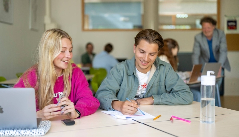 Twee studenten werken samen en hebben plezier.