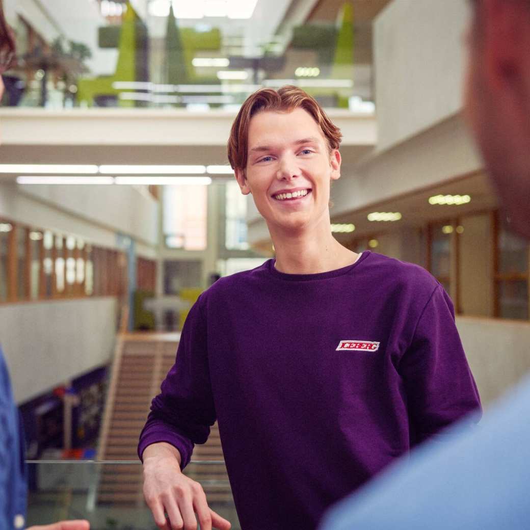 werving voltijd campagne, student met paars shirt bij balustrade