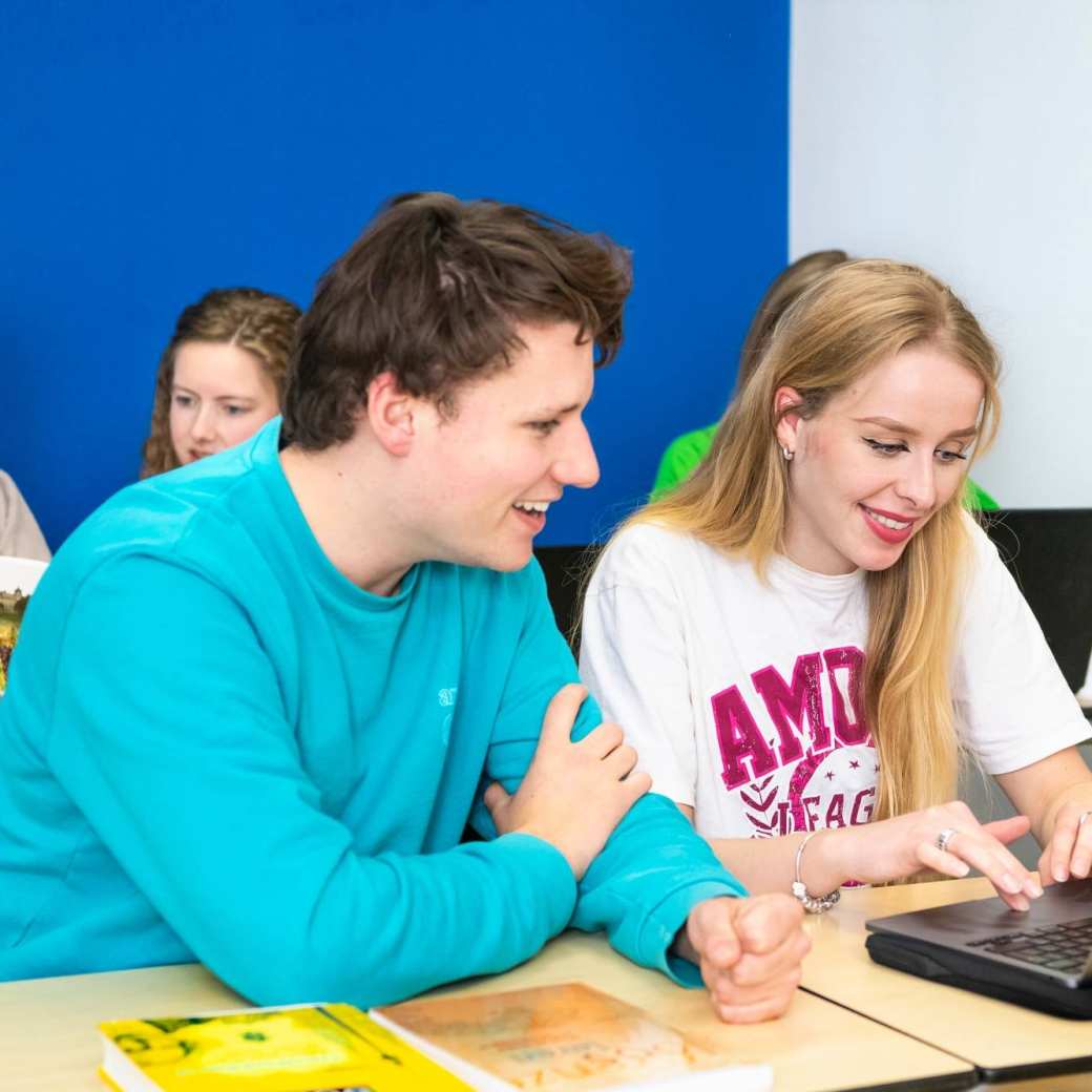 2 FastSwitchers Leraar Duits overleggen met elkaar in de klas.