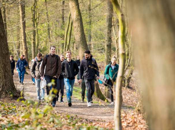 Groep biologie studenten lachend in het bos