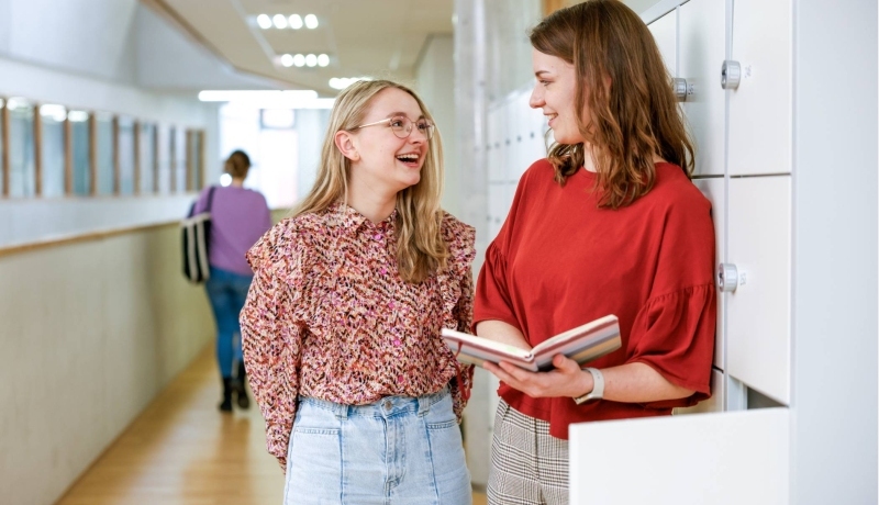 Twee studenten lachen naar elkaar