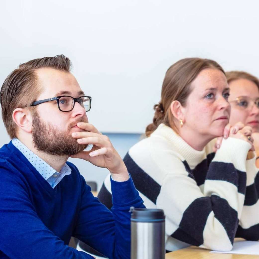 Man en drie vrouwen luisteren naar presentatie. Op de Groenewoudseweg. De opleiding maag-, lever-, darmverpleegkundige.